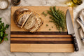 Handmade maple cutting board with walnut, cherry, and purple heart accent strips, non-slip rubber feet, 16 by 12 inches